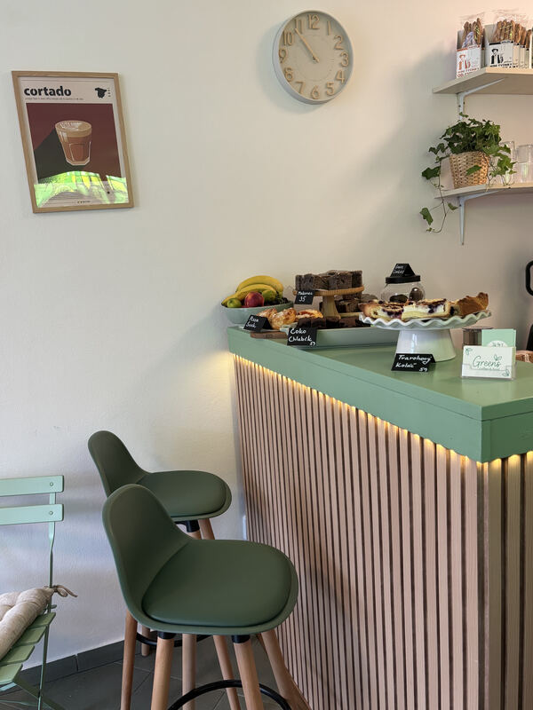 Bar s vitrínou dezertů a plakátem cortado